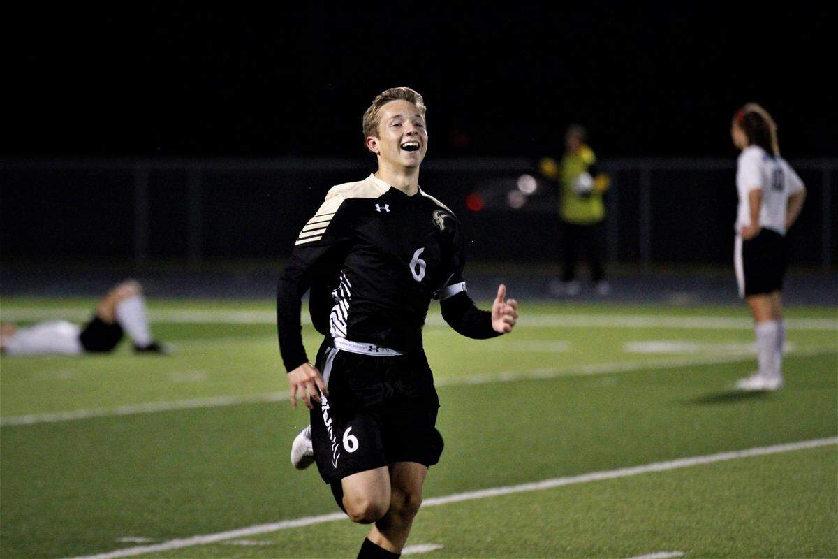Maize South junior defender Jack Manske runs to the stands to celebrate the Mavericks’ 2-1 regional championship win over Eisenhower on Thursday night. (Oct. 25, 2018)