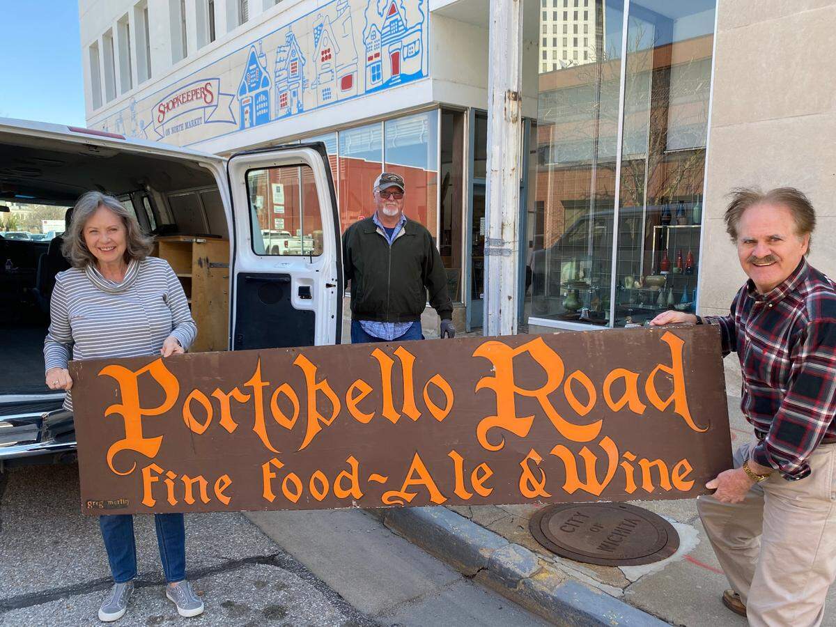 Sandy Rupert, left, and her husband Bill, center, recently donated the other half of the historic Portobello Road sign to Greg Kite and the Historic Preservation Alliance of Wichita and Sedgwick County. Kite, who is president of the alliance, picked up the first piece at an estate sale a few weeks ago.