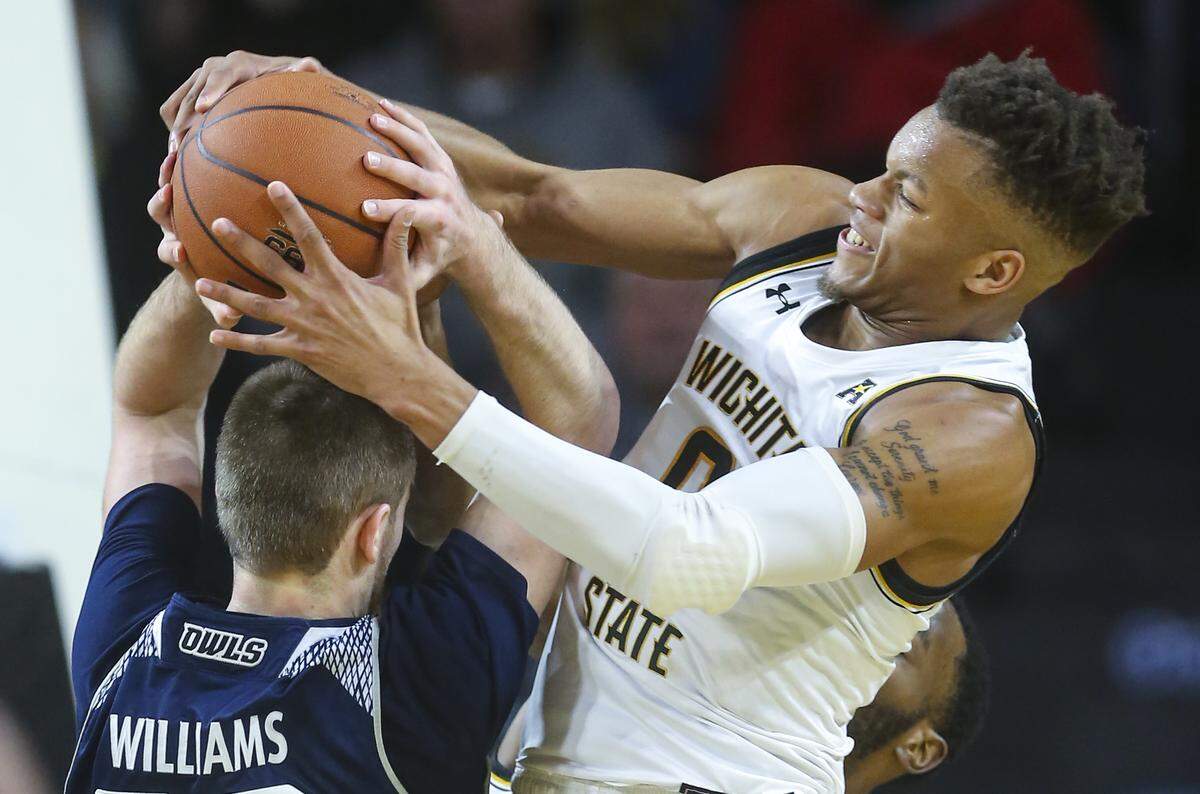 Wichita State guard Dexter Dennis fights Rice forward Jack Williams for a rebound during the first half of their game at Koch Arena on Sunday.