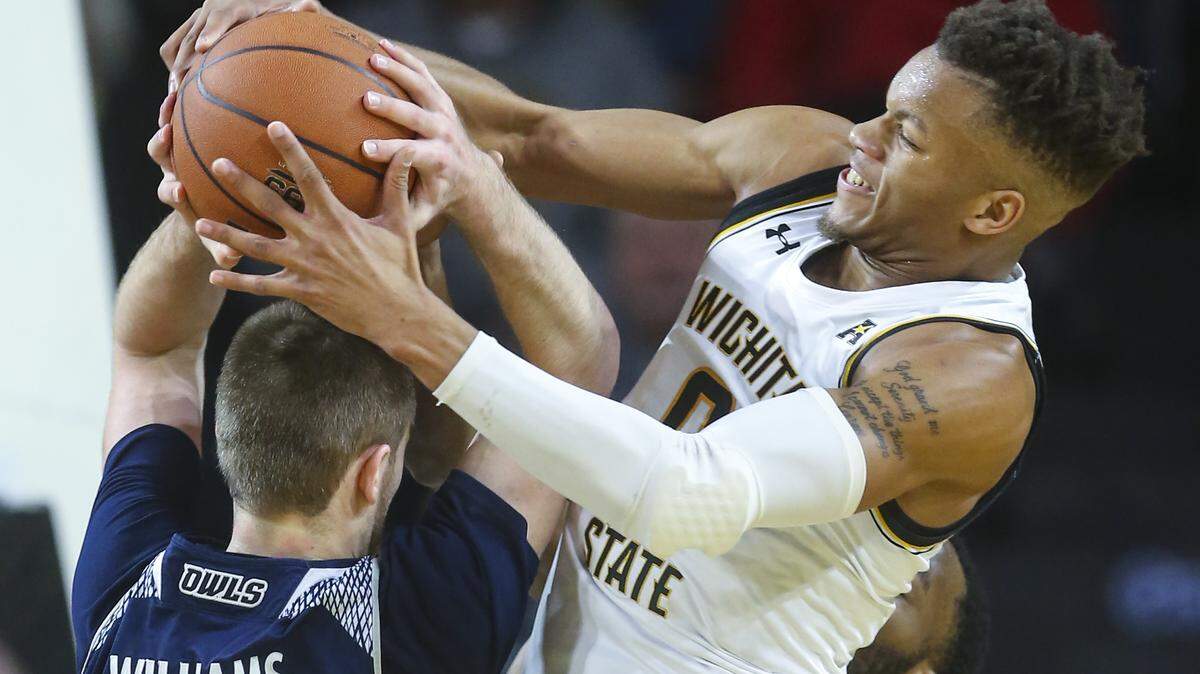 Wichita State guard Dexter Dennis fights Rice forward Jack Williams for a rebound during the first half of their game at Koch Arena on Sunday. 