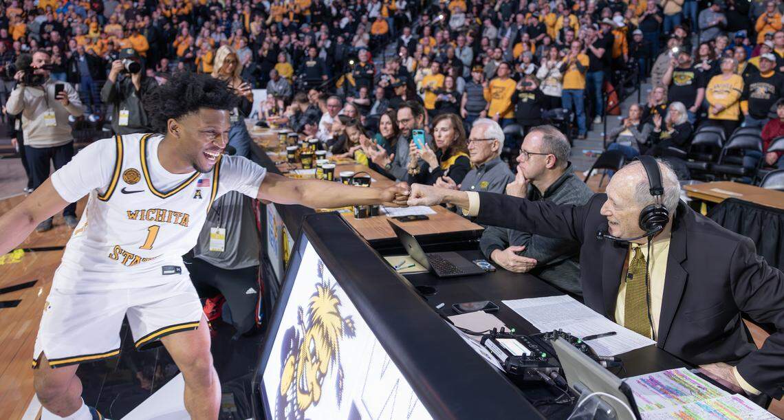 Wichita State player Kenyon Giles gives radio broadcaster Mike Kennedy a fist bump during player introductions before the game against Temple at Koch Arena on Saturday. Kennedy was honored at halftime for his near-quarter century of calling games for the team.