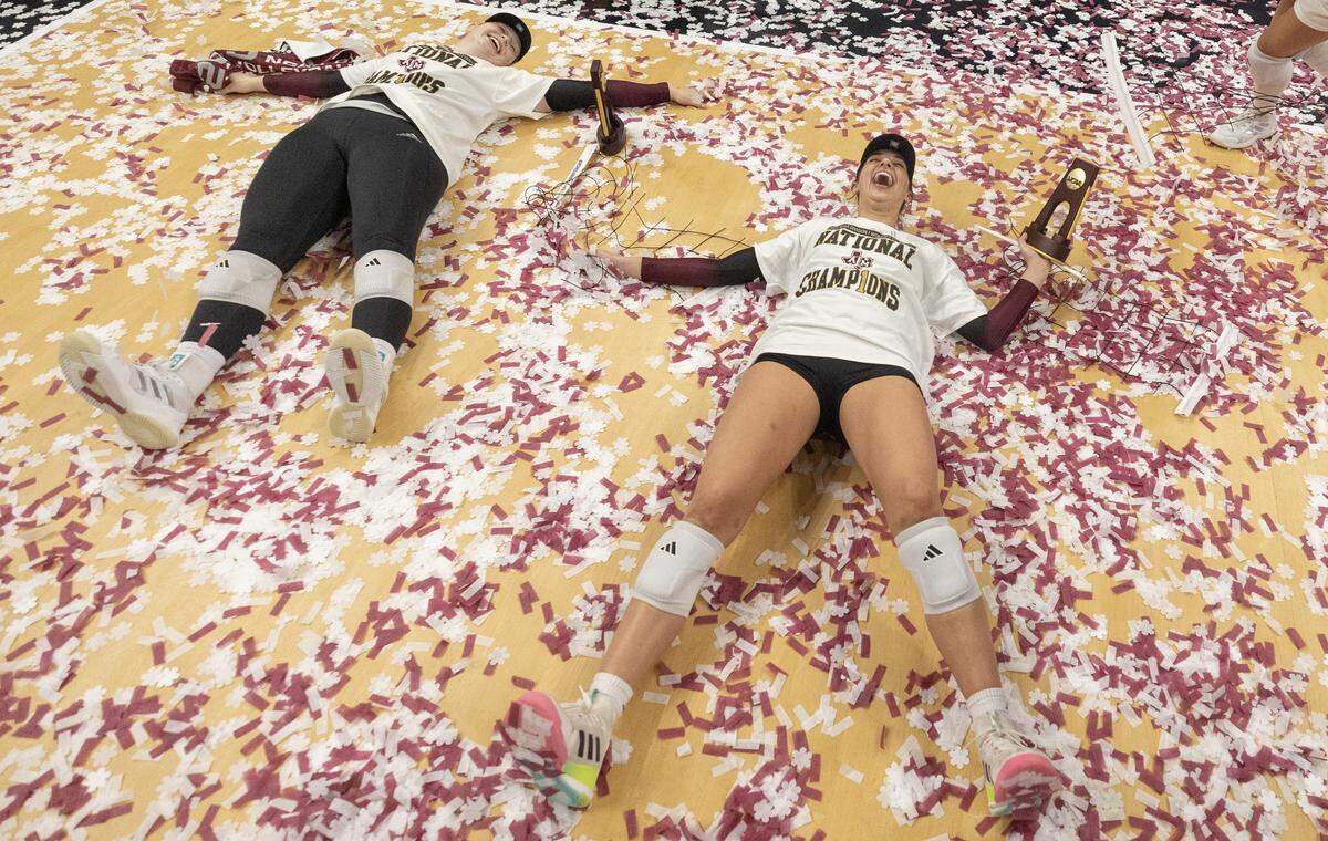 Texas A&M’s Logan Lednicky makes a snow angel in confetti after the Aggies defeated Kentucky in the championship match of the NCAA Women’s Volleyball Championship on Sunday afternoon at the T-Mobile Center.