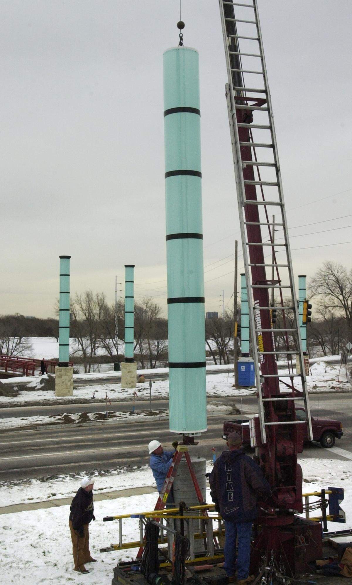 Workers from Luminous Neon in Hutchinson place one of the light columns at the corner of McLean and Central in 2000.