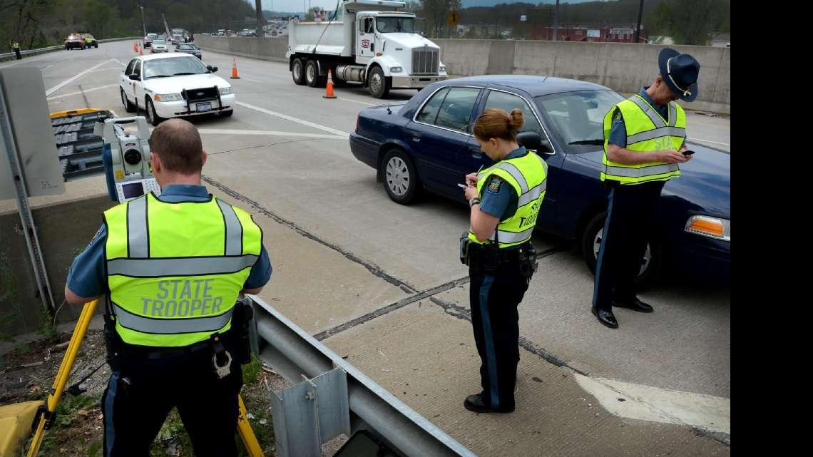 Members of the The Kansas State Highway Patrol investigated an accident in May that claimed the life of 26-year-old Jamie Frecks of Kansas City, Kansas. At the Southwest Boulevard and Mission Road exit of northbound I-35, Trooper Mike Hamilton (left) used a laser device to help map out the area where the bus carrying a group of friends attending a bachelorette party came to a stop after Frecks had fallen out.