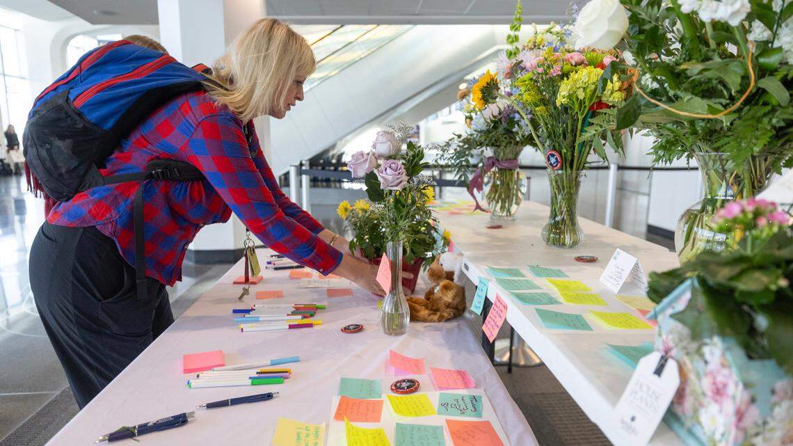 Laura Formsma, an American Airlines employee, leaves flowers at a table set up for people to leave messages of condolence at Wichita’s Eisenhower Airport on Friday.
