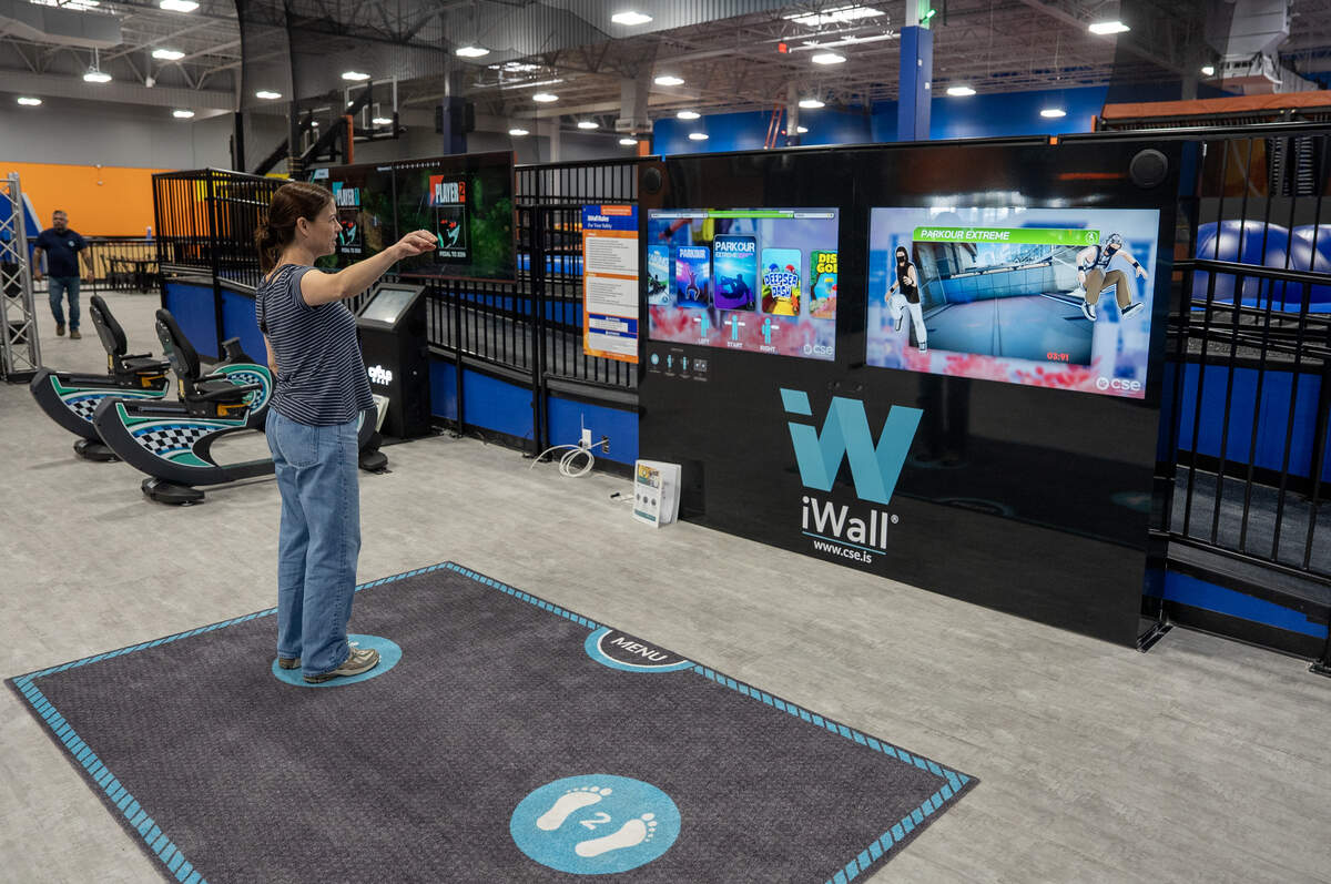 Sky Zone of Wichita co-owner Ashley Youngdale demonstrates an interactive iWall.