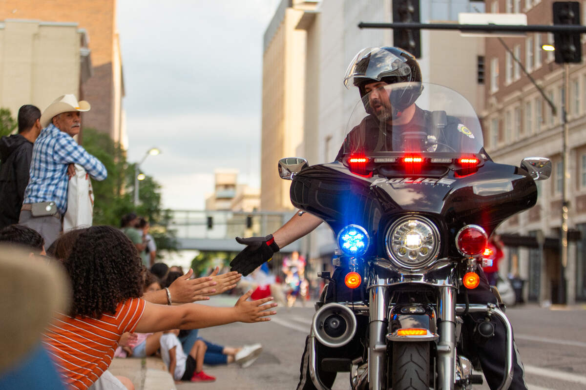 A member of the Wichita Police Department motorcycle unit pauses to high-five attendees on Market.