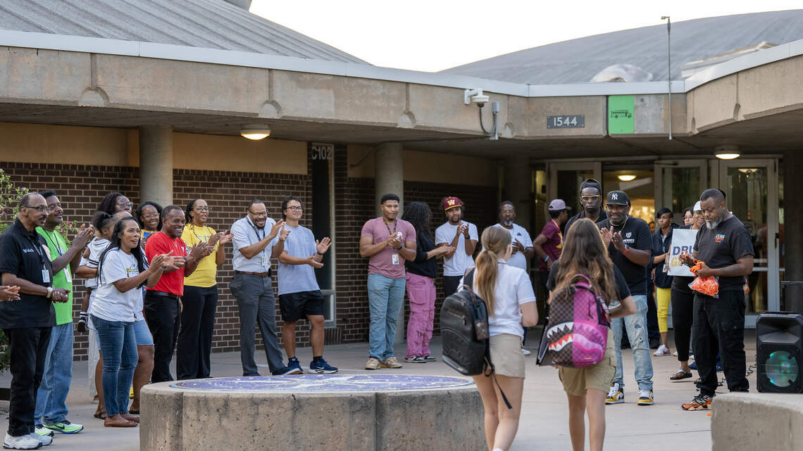 Community volunteers cheer on Wichita students as they return to school