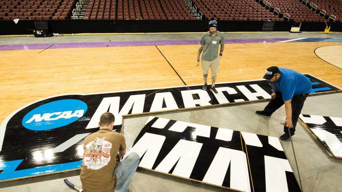 Workers install NCAA court at Intrust Bank Arena over the weekend.