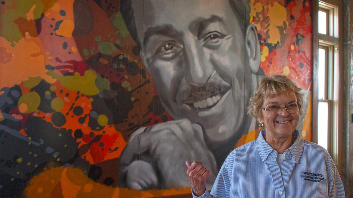 Walt Disney Hometown Museum director Kay Malins points to a mural of Disney in the Missouri town of Marceline.