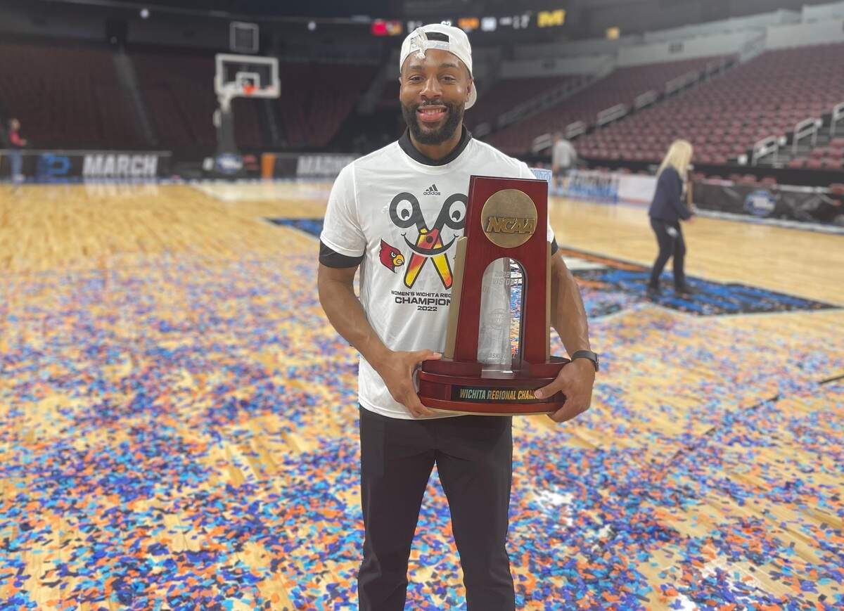 Wichita native LaMont Russell, the video coordinator for the Louisville women’s basketball team, celebrates in his hometown with the regional championship trophy.