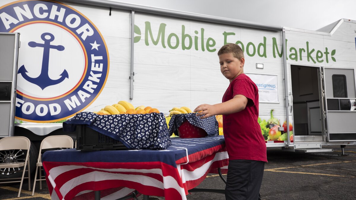 Brad Crane, 7, grabs an orange outside the Anchor Mobile Food Market during an event Saturday in Winfield. The food truck wants to make healthy food options available to people in rural communities.