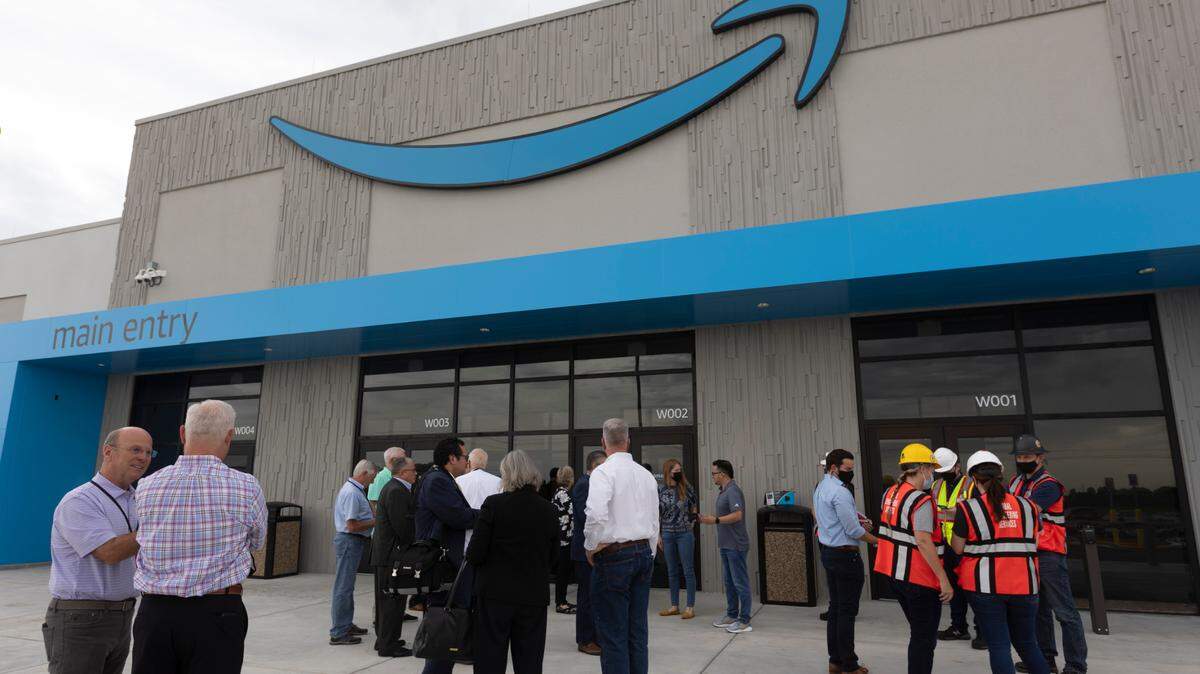 Local, state and federal dignitaries get ready to take a tour of the new Amazon distribution center in Park City on Friday.