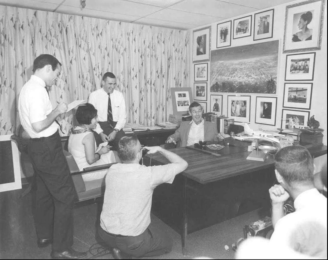 Johnny Carson sits at Learjet founder Bill Lear’s desk in 1965. Al Higdon, who went to work for the company a month after its first plane was certified and stayed until 1971 when he left to start what became the Sullivan Higdon & Sink ad agency, is sitting on the credenza to his side.