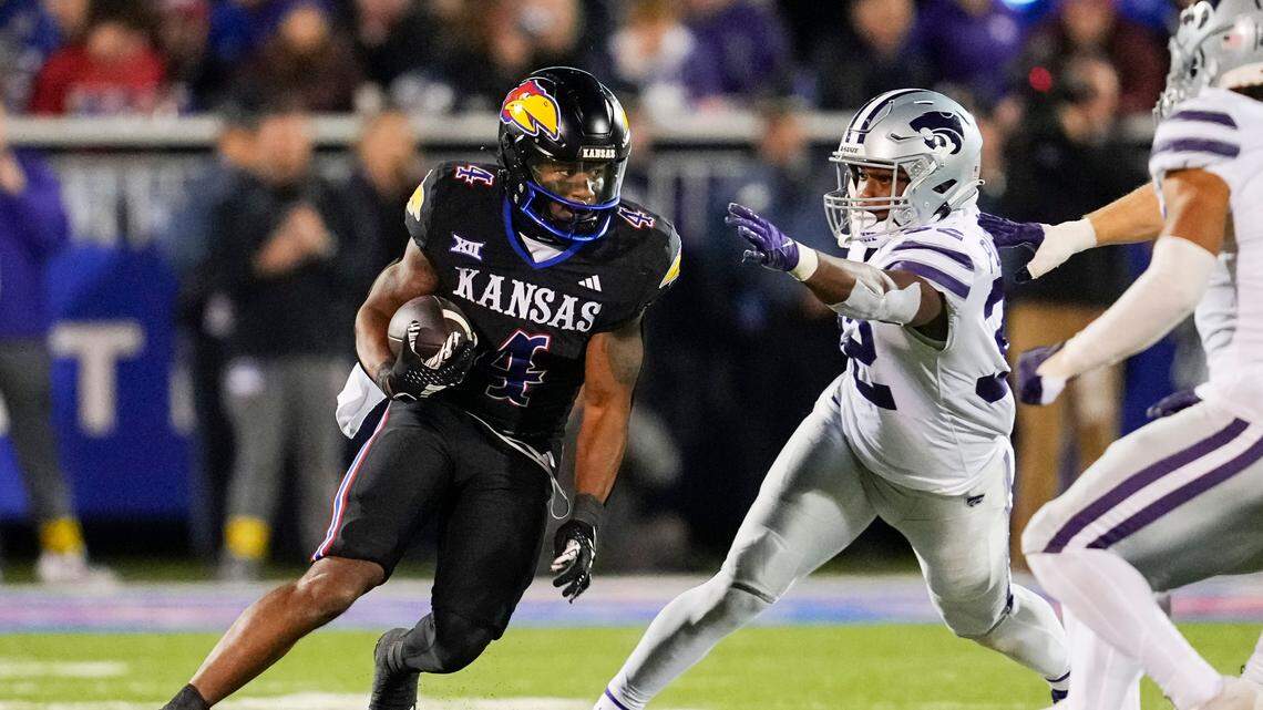 Kansas Jayhawks running back Devin Neal (4) runs the ball against Kansas State Wildcats linebacker Desmond Purnell (32) during the second half at David Booth Kansas Memorial Stadium on Nov. 18, 2023.