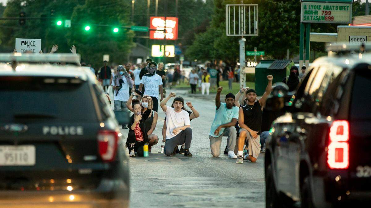 In this file photo, protesters kneel down in front of some Wichita Police vehicles on June 2, 2020. An Associated Press review found that hundreds of bias complaints filed against Kansas law enforcement over the past 10 years rarely resulted in any consequences for officers.