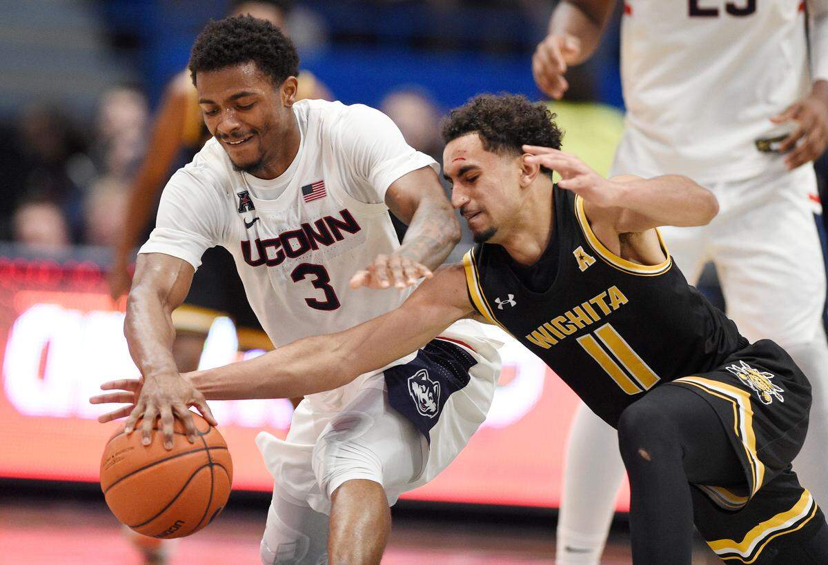 Connecticut’s Alterique Gilbert, left, and Wichita State’s Noah Fernandes fight for control of the ball in the first half of an NCAA college basketball game, Sunday, Jan. 12, 2020, in Hartford, Conn. (AP Photo/Jessica Hill)