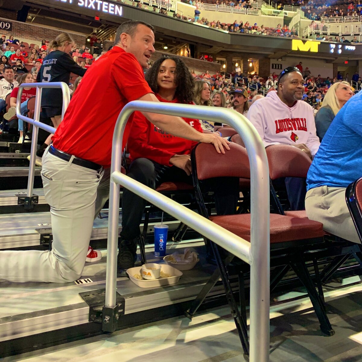 Louisville coach Jeff Walz visits with Wichita Heights senior Zyanna Walker, a Louisville signee, in the stands following the Cardinals’ Sweet 16 win in Wichita.