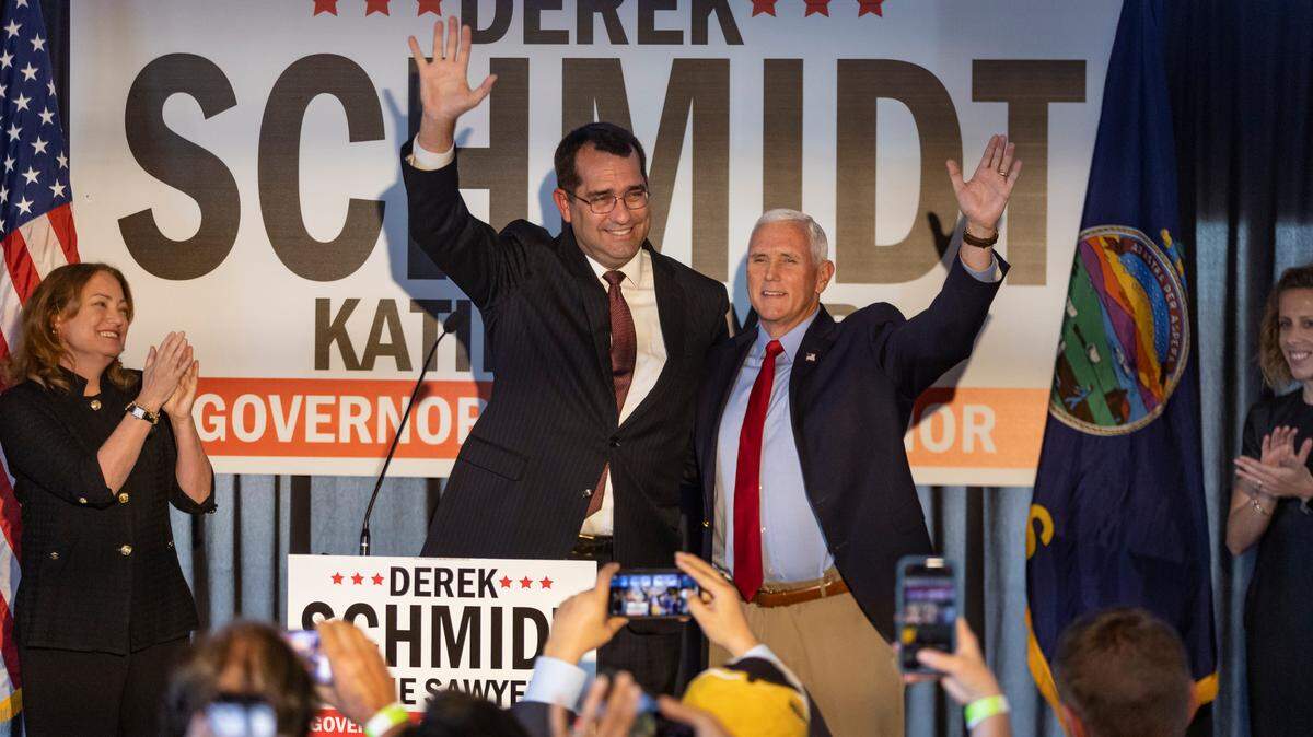 Former vice president Mike Pence waves alongside Republican gubernatorial candidate Derek Schmidt on Friday in Wichita.