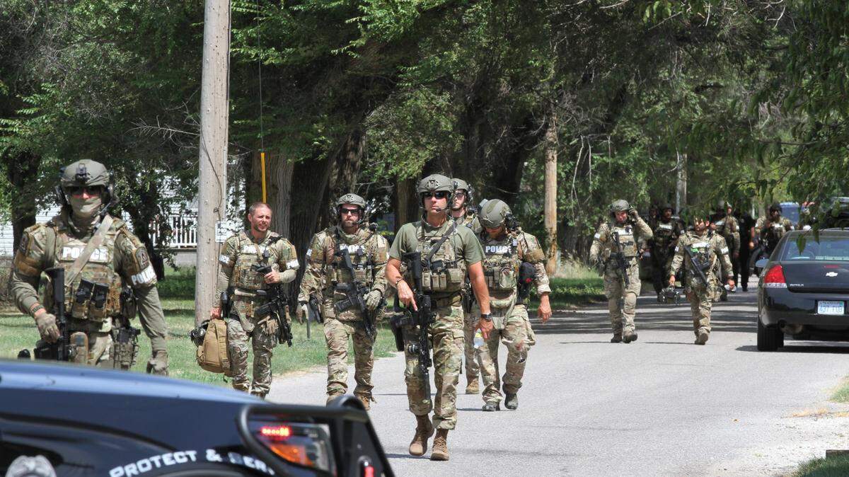 Officers of the SWAT team retreating from a home where a five-hour standoff resulted in a 38-year-old man being rushed to the hospital on Sunday in north Wichita.