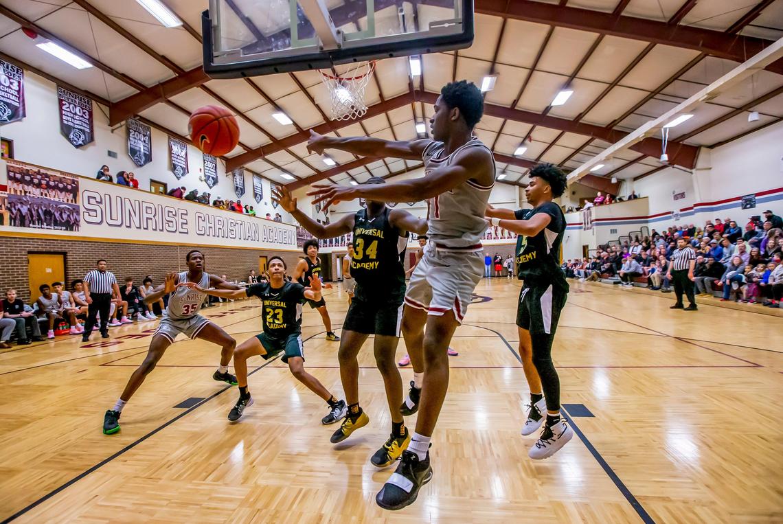 Sunrise Christian AcademyÕs Kenny Photo dishes the ball after penetrating to the basket against the Universal Academy Eagles in Bel Air Thursday night. Sunrise Christian Academy just north of Wichita, has produced 63 Division I menÕs college basketball players.