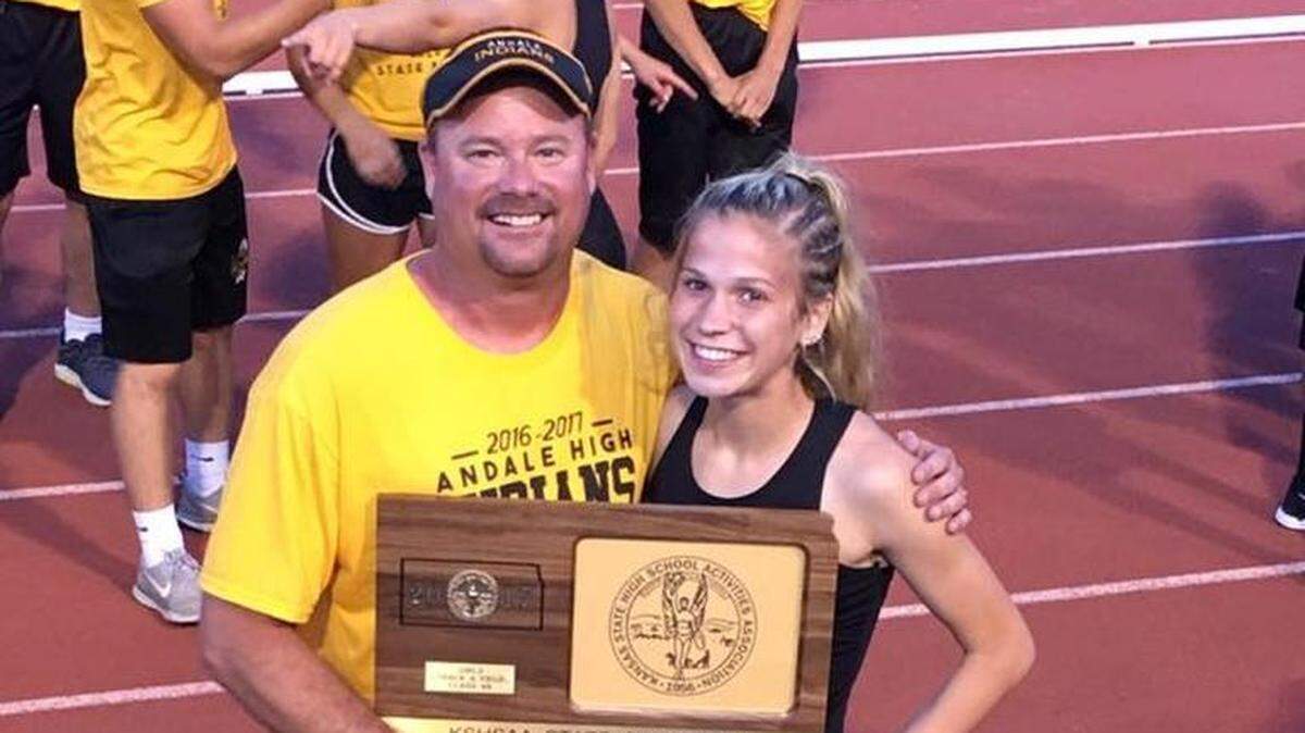Greg Smarsh poses with the girls team championship with his daughter, Abby, a junior who won the 300 hurdles title.

