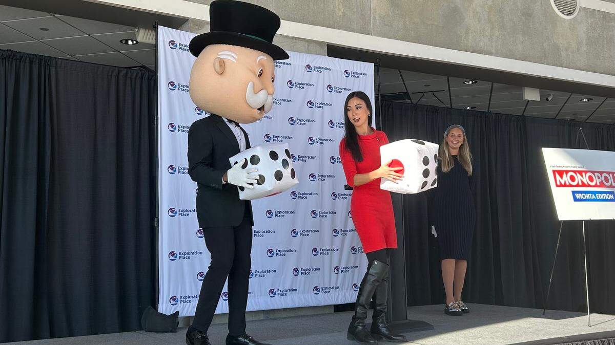 Wichita Mayor Lily Wu prepares to roll the dice with Mr. Monopoly at Exploration Place on Wednesday.