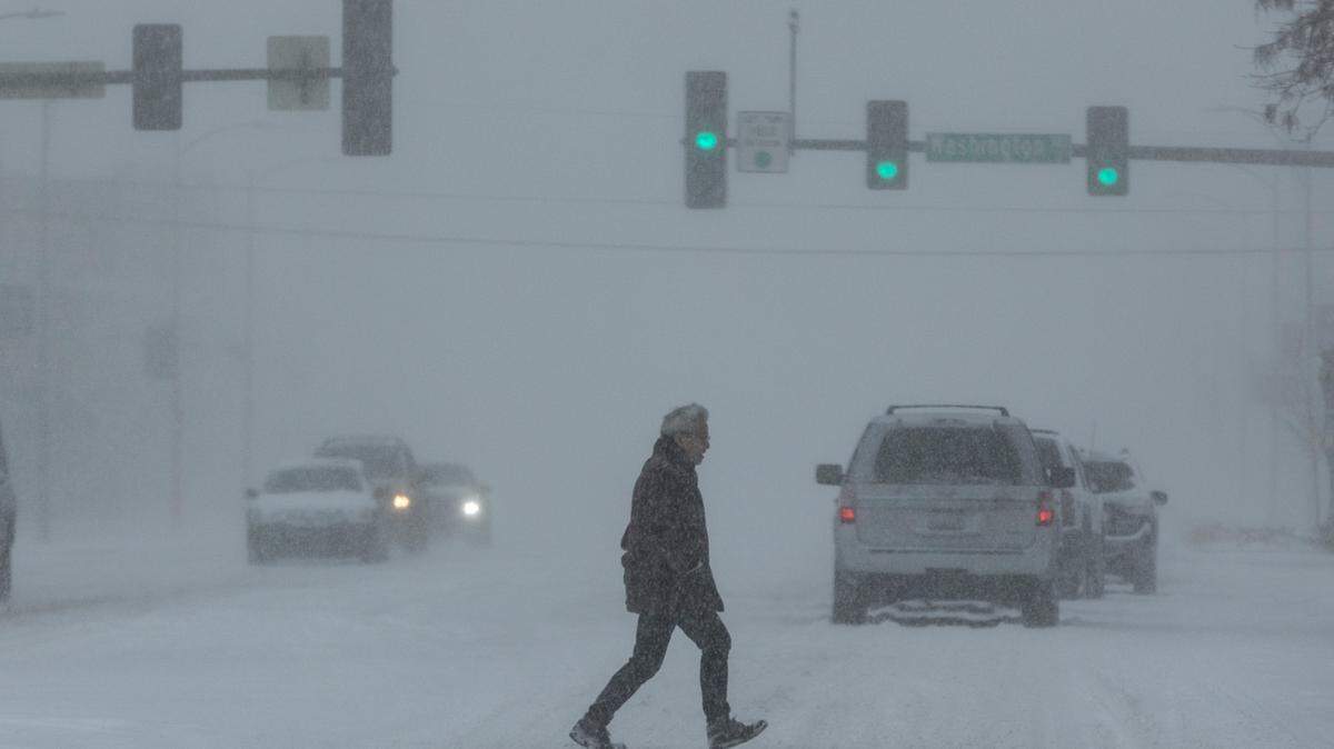 File photo of a pedestrian crossing the street amid a winter storm in Wichita, Kansas.