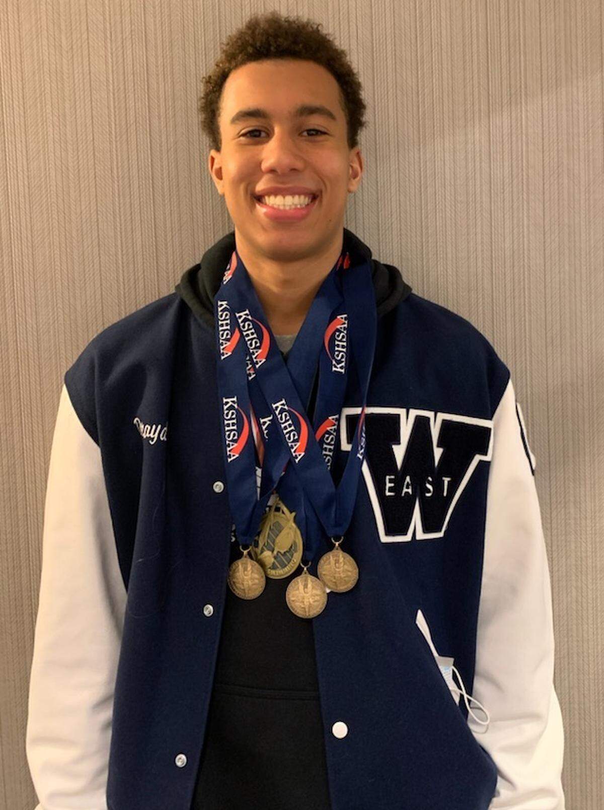 Wichita East junior Drayden Bell poses with his state medals after Friday’s state swim meet in Lenexa.
