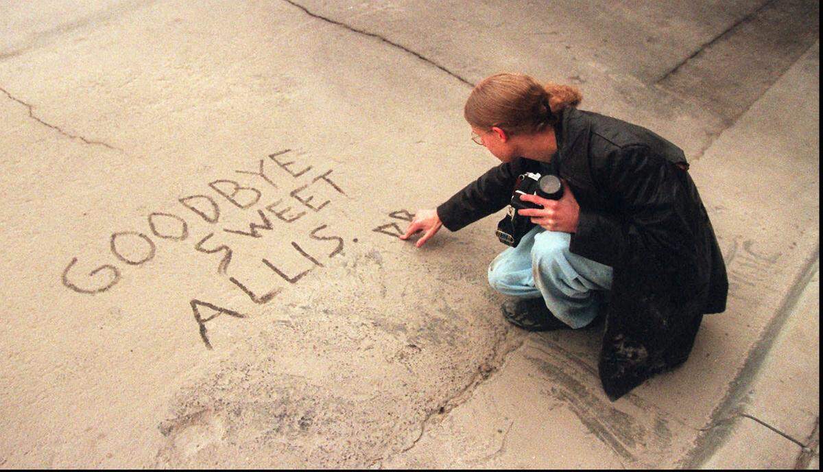 Derek Butler used thick dust from the 1996 Allis Hotel implosion to write a note to the beloved building.