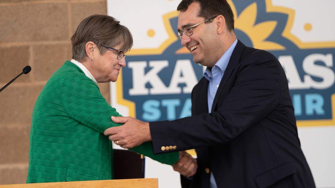 Kansas Governor Laura Kelly, left, and Kansas Attorney General Derek Schmidt shake hands after their debate at the Kansas State Fair in Hutchinson on Sept. 10, 2022.