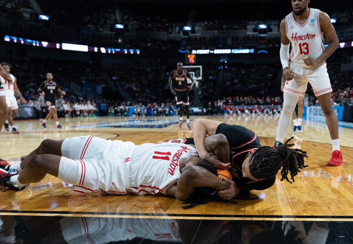 Houston’s Joseph Tugler and SIU-Edwardsville’s Kyle Thomas scramble for the ball in the first round of the 2025 NCAA Division I Men’s Basketball Championship.