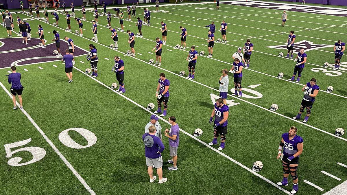 Kansas State football coach Chris Klieman speaks with assistant coaches as the Wildcats prepare for a preseason practice.