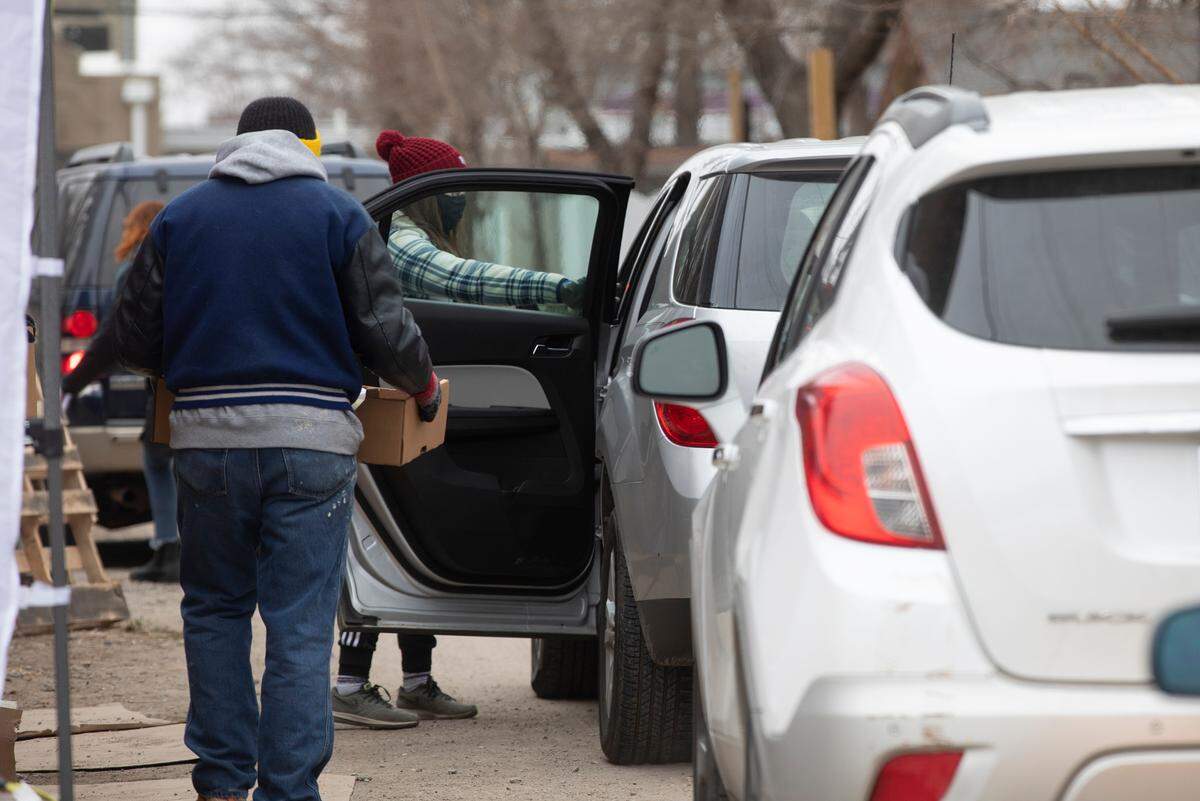 David Bateman, a volunteer at First Metropolitan Community Church Table of Hope, delivers food to a family during their weekly food giveaway. The group serves food to 1,500-1,700 families per week. (December 15, 2020)