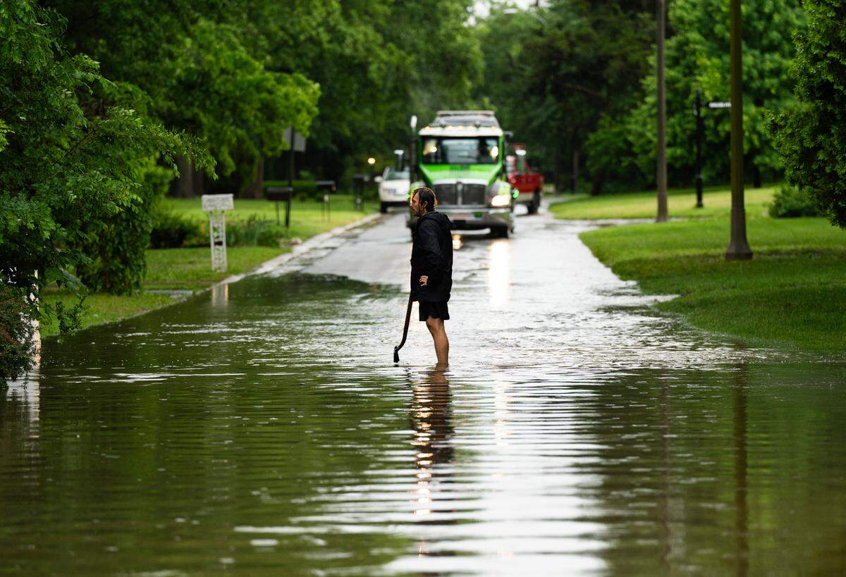Adam Runner uses a shovel to clear clogged drains near his home in Eastborough on Tuesday afternoon.