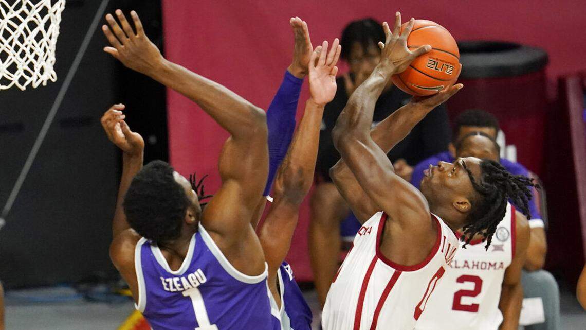 Oklahoma forward Victor Iwuakor, right, goes up for a shot while defended by Kansas State forward Kaosi Ezeagu (1) and guard Selton Miguel, center, during the first half of an NCAA college basketball game Tuesday, Jan. 19, 2021, in Norman, Okla. (AP Photo/Sue Ogrocki)