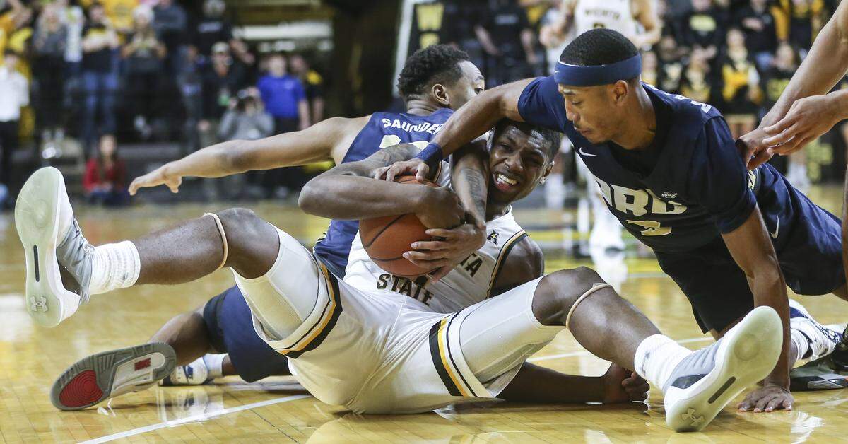 Wichita State guard Jamarius Burton grabs a loose ball from Oral Roberts guard Kaelen Malone during the second half of their game at Koch Arena on Wednesday.