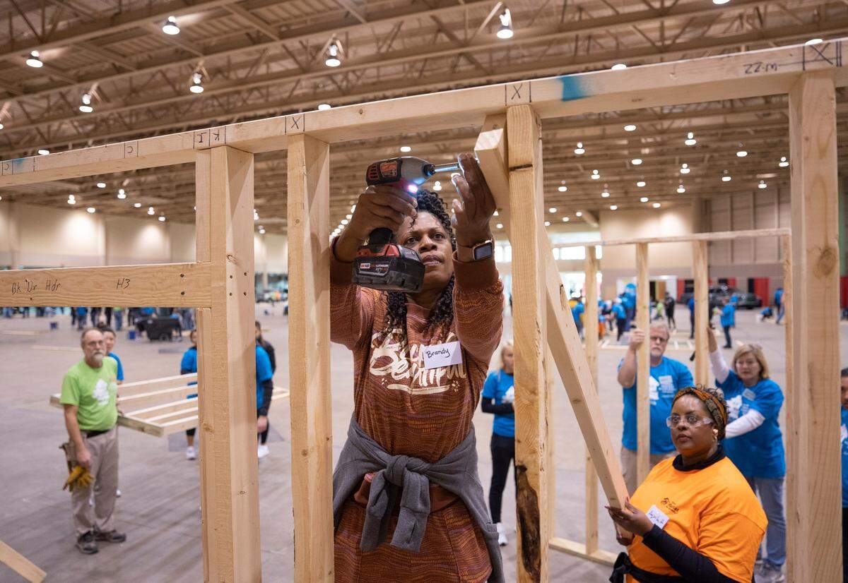 Service for Change participants will try to raise $100,000 by April 2025, which they will donate to Habitat for Humanity. In this photo, volunteer Brandy Evans, center, helps build walls for three Wichita Habitat for Humanity Homes during the organization’s 2023 Martin Luther King Day of Service event.