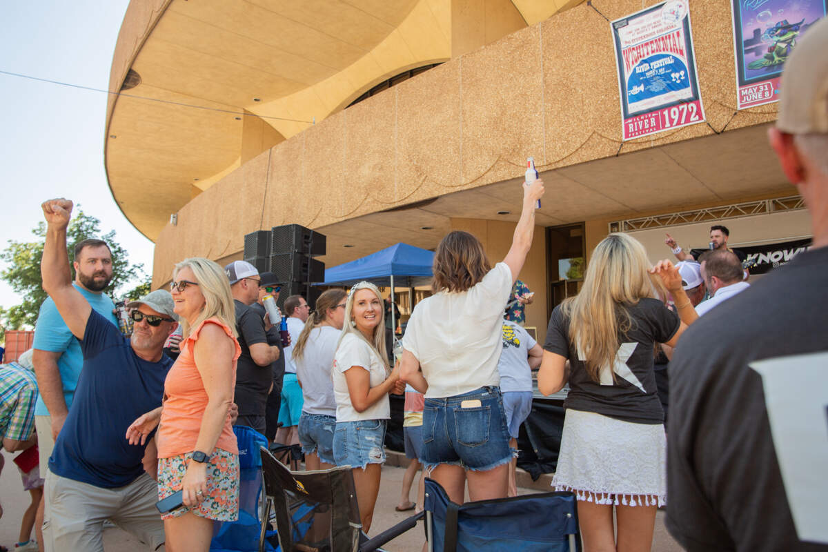Riverfest attendees dance to Dixon Knowles, a local cover-band in Wichita, during the second day of the nine-day festival. Dixon Knowles played a variety of rock hits, such as “Last Night” by The Strokes.