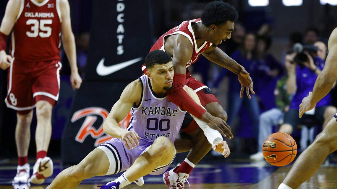 Kansas State guard Mike McGuirl (00) and Oklahoma guard Marvin Johnson, top, go after the ball during the first half of an NCAA college basketball game on Saturday, March 5, 2022, in Manhattan, Kan. (AP Photo/Colin E. Braley)