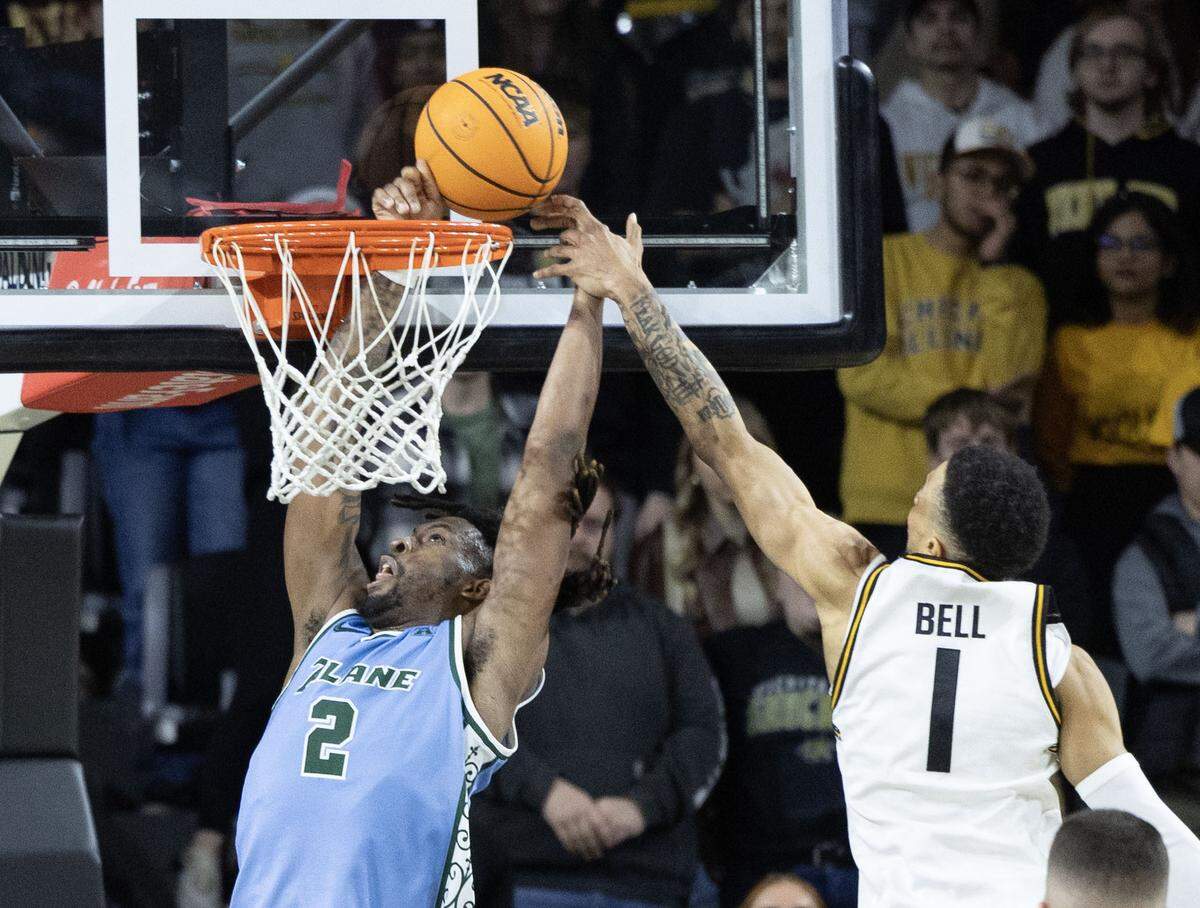 Wichita State’s Xavier Bell blocks the shot of Tulane’s Gregg Glenn III during the second half of their game on Sunday at Koch Arena. 