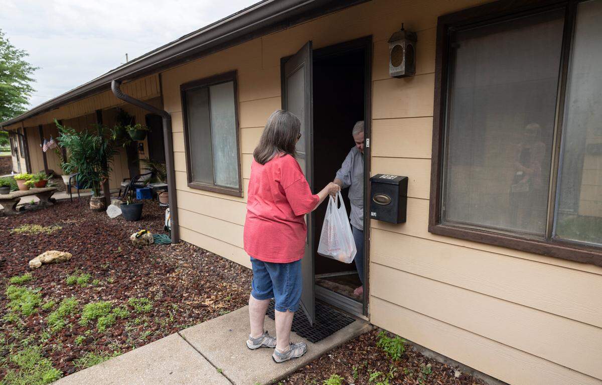Jana Shockey, a volunteer driver for Meals on Wheels, delivers a pre-packaged meal to a client near West High on Wednesday. The Meals on Wheels programs is feeling the pinch of higher food and gas prices.