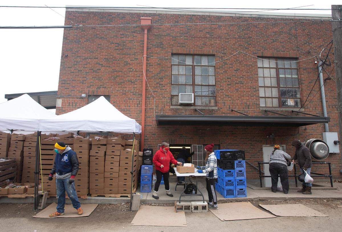 Volunteers at First Metropolitan Community Church Table of Hope prepare food to give away during their weekly food giveaway. The group serves food to 1,500-1,700 families per week. (December 15, 2020)