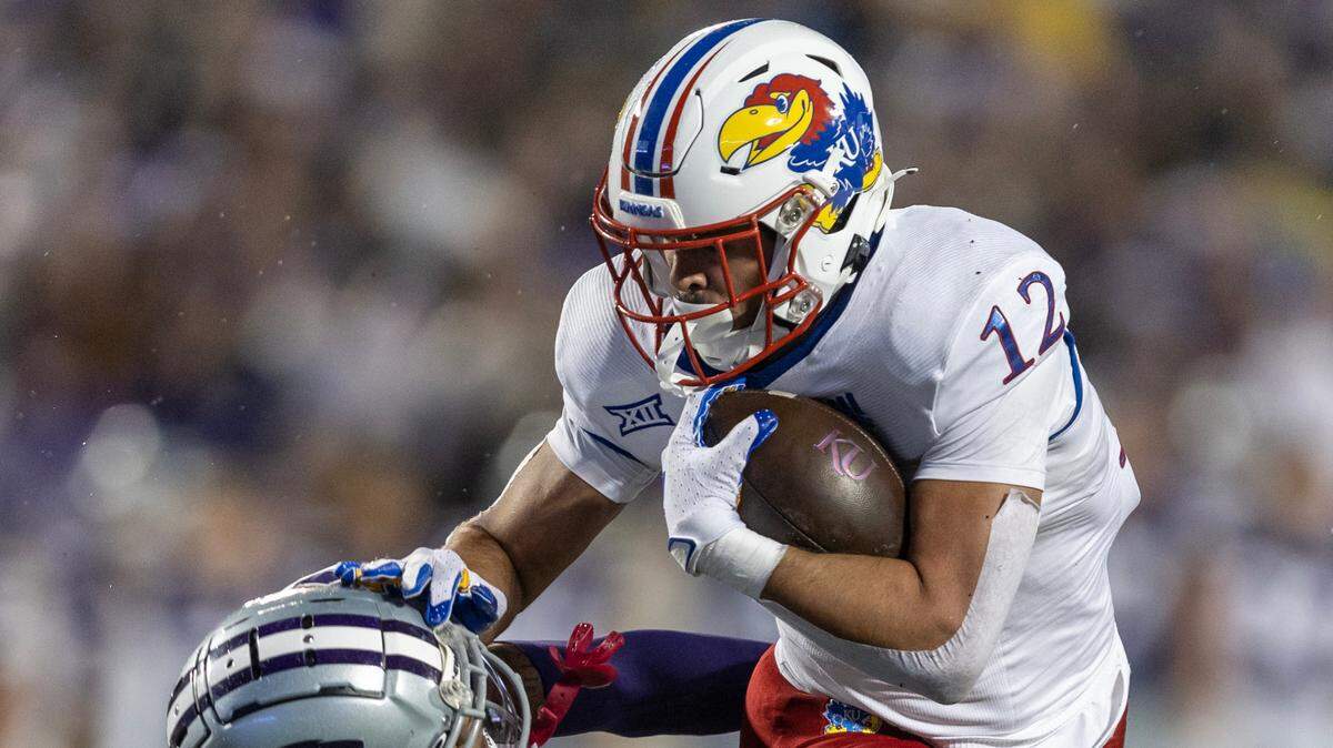Kansas’ Torry Locklin breaks the tackle of Kansas State’s Julius Brents to score a touchdown during the first half on Saturday night in Manhattan.