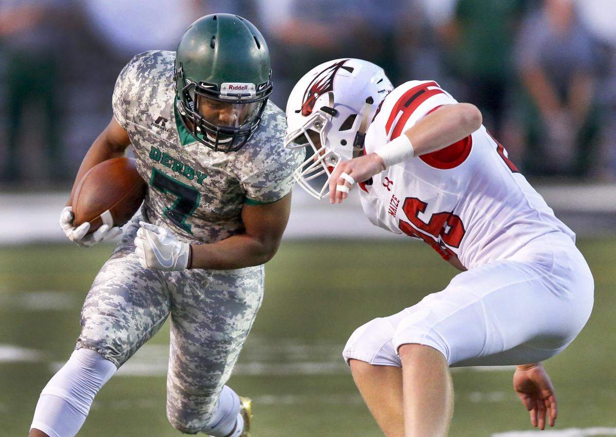 Derby’s Tre Washington, left, makes his way downfield against maize’s Carson Shively during the second quarter at Derby. (Sept. 15, 2017)