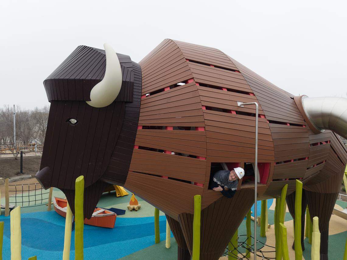 Exploration Place president and CEO Adam Smith pokes his head out of the 20-foot bison that’s part of the museum’s new $25 million Adventure Playscape.