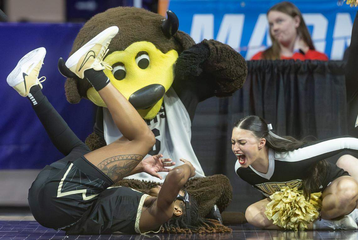 A Colorado cheerleader, along with the team’s mascot, show their approval to Jaylyn Sherrod after Sherrod was fouled while driving to the basket in the second half of Colorado’s 63-50 win on Sunday in Manhattan.