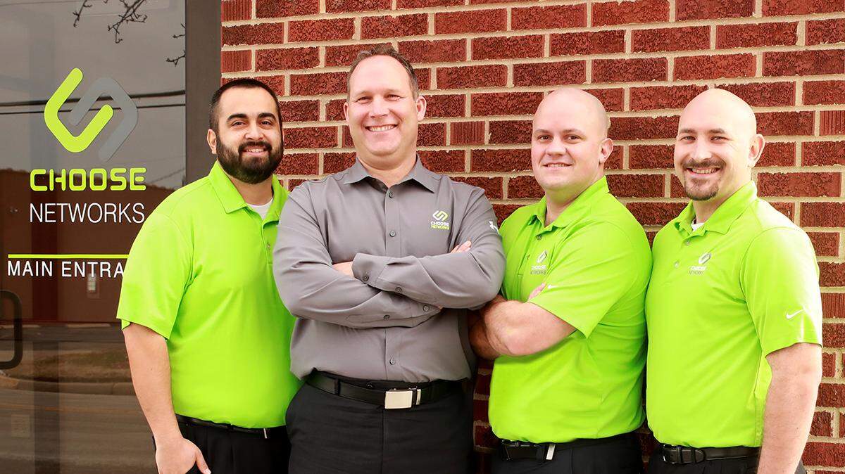 Choose Networks owner Chris Hoose (in gray shirt) is flanked by, from left, COO Niklas Herrera, service manager Shane McCallie and technical account manager Keith Hoose.