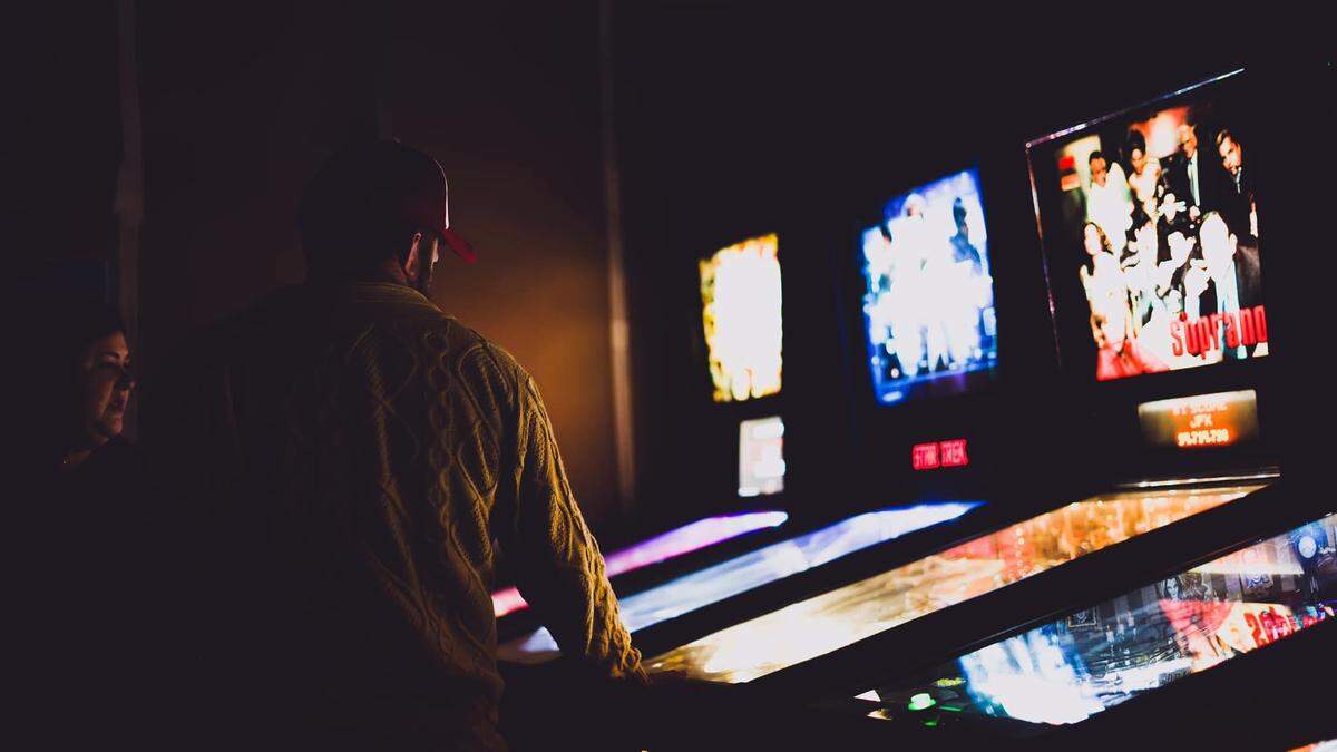 People try out the new pinball machines at Kirby’s FlipSide, a new pinball arcade next door to Kirby’s Beer Store.