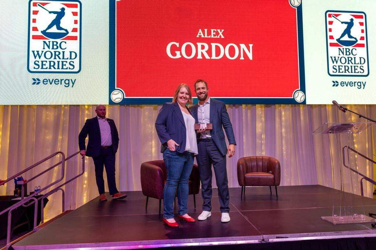 NBC World Series tournament director Katie Woods presents former Kansas City Royals standout Alex Gordon a plaque for being inducted into the NBC Hall of Fame.